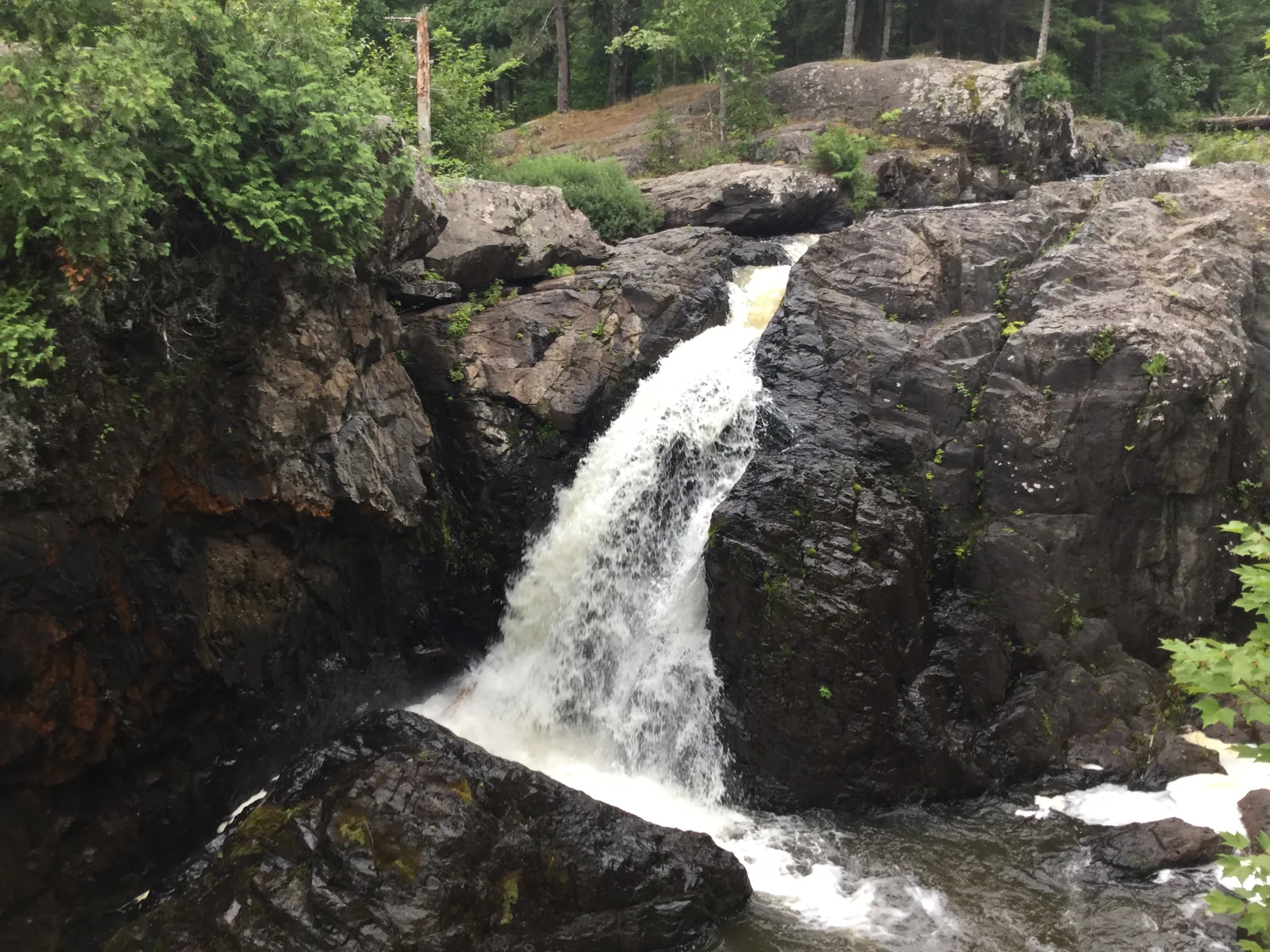 A narrow chute of Dead River Falls pouring between dark rock walls in the gorge west of Marquette.